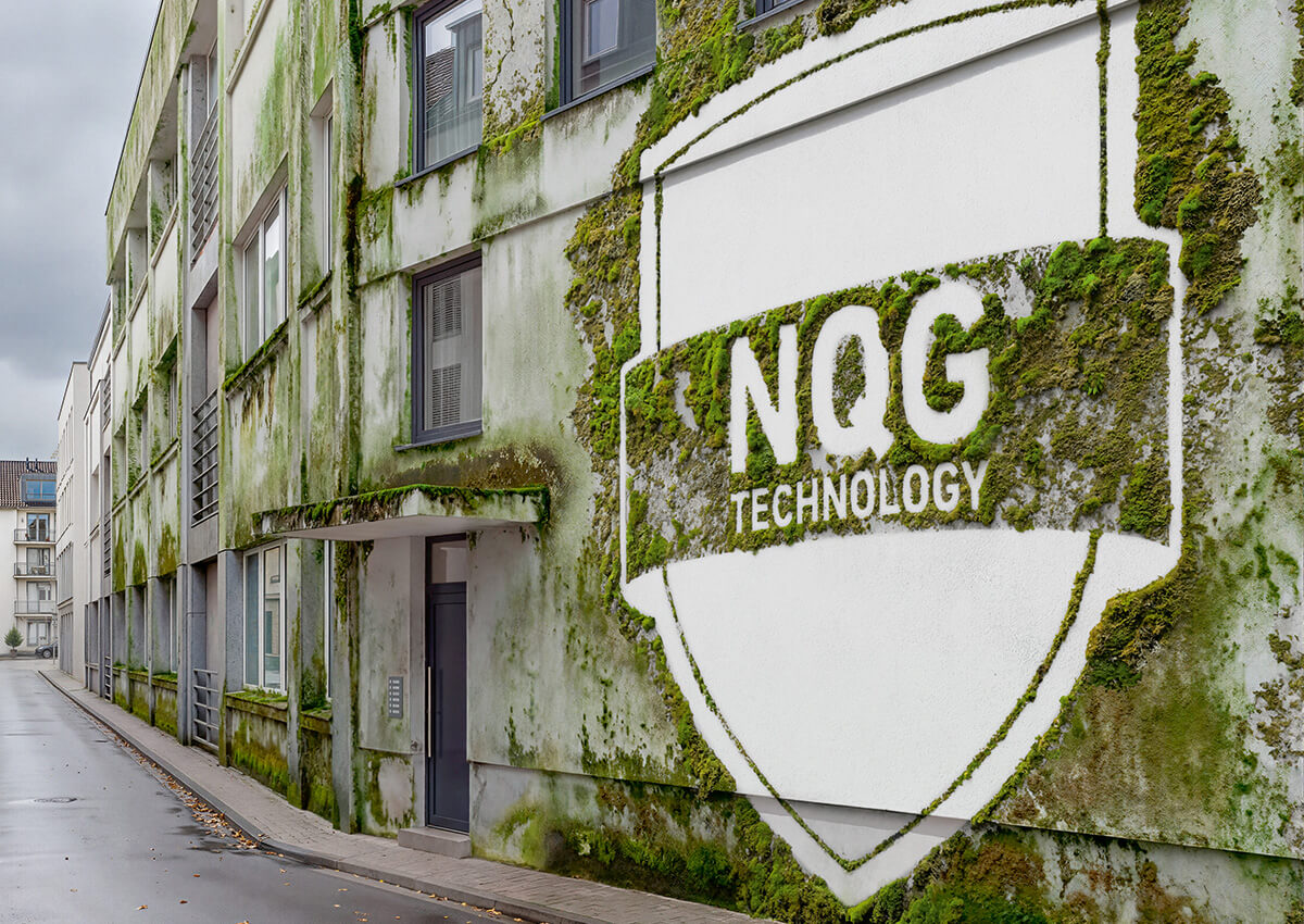 Fassadenwand eines Gebäudes mit starkem Moosbewuchs und einem großen, freigelassenen Bereich in Form eines Schildes mit der Aufschrift 'NQG TECHNOLOGY'